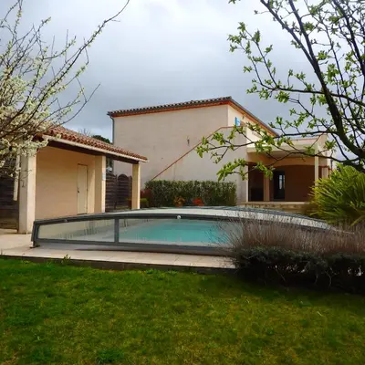 a swimming pool in front of a house at L'oustal des Fontanilles in Castelnaudary