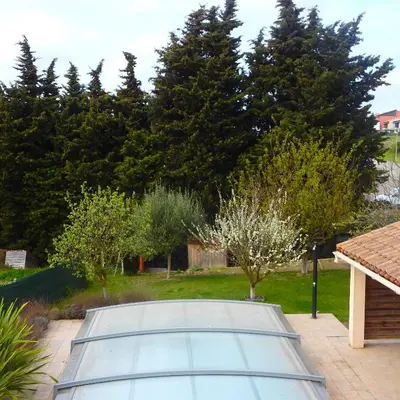 a tennis court in a yard with trees at L'oustal des Fontanilles in Castelnaudary