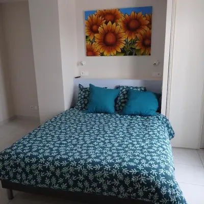 a bed in a bedroom with a painting on the wall at L'oustal des Fontanilles in Castelnaudary