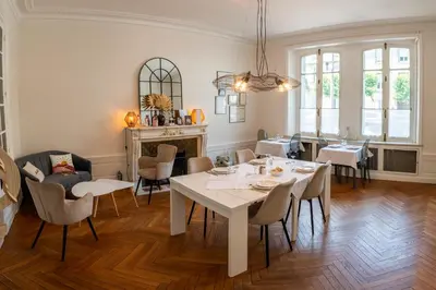 a dining room with a white table and chairs at La Grande Maison Mazamet in Mazamet