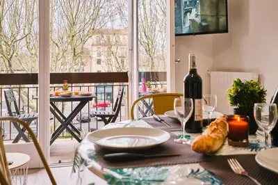 a table with a plate of food and a bottle of wine at Tout confort ! Climatisation, Centre-ville, Parking, Terrasse, WiFi, Netflix in Carcassonne