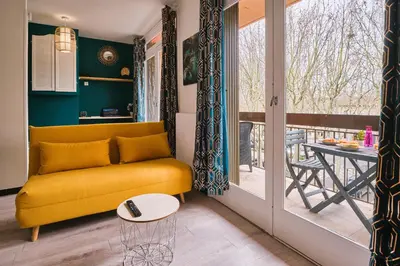 a living room with a yellow couch and a table at Tout confort ! Climatisation, Centre-ville, Parking, Terrasse, WiFi, Netflix in Carcassonne