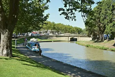 a boat is parked on the side of a river at Tout confort ! Climatisation, Centre-ville, Parking, Terrasse, WiFi, Netflix in Carcassonne