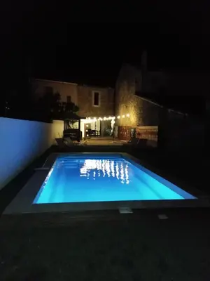 a swimming pool lit up at night at maison a bizanet avec piscine in Bizanet