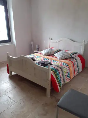 a bed with a wooden frame in a bedroom at maison a bizanet avec piscine in Bizanet