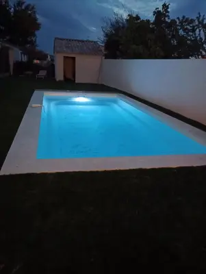 a swimming pool in a backyard at night at maison a bizanet avec piscine in Bizanet