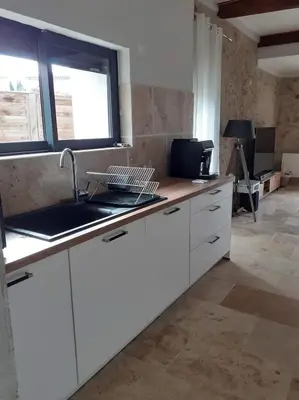 a kitchen with white cabinets and a sink at maison a bizanet avec piscine in Bizanet