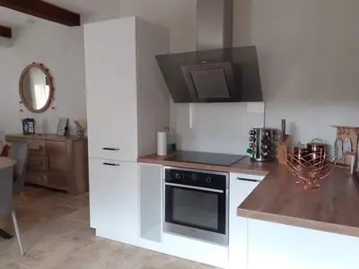 a kitchen with white cabinets and a stove top oven at maison a bizanet avec piscine in Bizanet