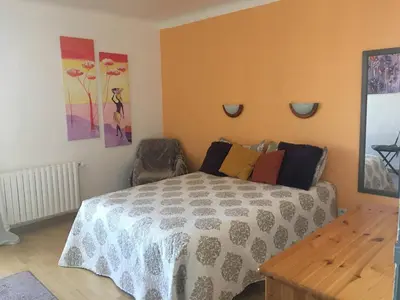 a bedroom with a bed and paintings on the wall at Location de Chambres, Séjour près des Grands Buffets Narbonne in Narbonne