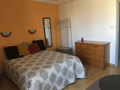 a bedroom with a bed and a dresser and a mirror at Location de Chambres, Séjour près des Grands Buffets Narbonne in Narbonne
