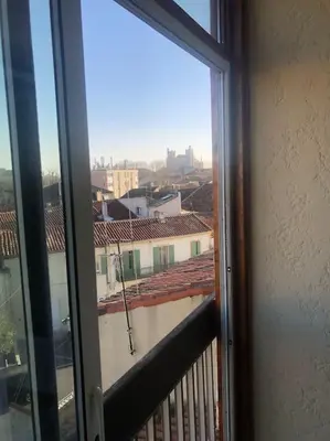 a window with a view of a city from a balcony at Location de Chambres, Séjour près des Grands Buffets Narbonne in Narbonne