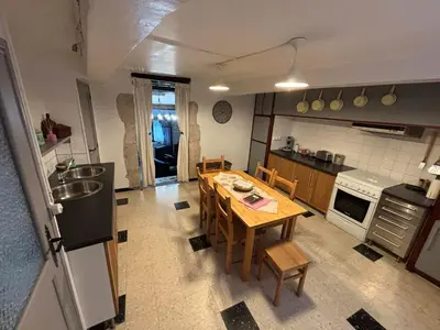 a kitchen with a wooden table and a dining room at Chez Nath et Oli in Caunes-Minervois