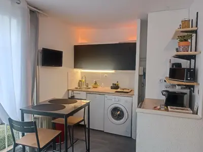 a kitchen with a table and a washing machine at Studio Gruissan La Presqu'île 2 in Gruissan