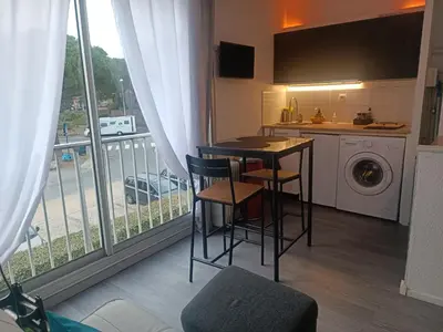 a kitchen with a table and chairs next to a window at Studio Gruissan La Presqu'île 2 in Gruissan