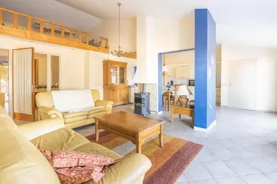 a living room with a couch and a table at Maison des papillons in Ouveillan