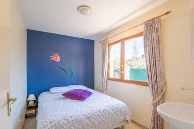 a bedroom with a bed and a window and a sink at Maison des papillons in Ouveillan