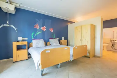 a bedroom with a bed and a blue wall at Maison des papillons in Ouveillan