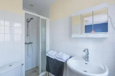 a white bathroom with a sink and a shower at Maison des papillons in Ouveillan