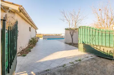 a gate to a driveway with a fence at Maison des papillons in Ouveillan