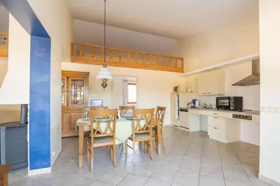 a kitchen and dining room with a table and chairs at Maison des papillons in Ouveillan