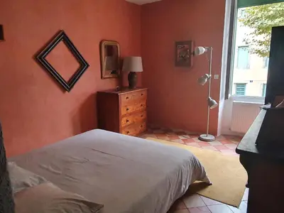 a bedroom with orange walls and a bed and a window at Très belle maison chaleureuse au coeur de Mirepoix in Mirepoix