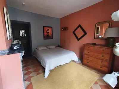 a bedroom with a bed and a dresser and a mirror at Très belle maison chaleureuse au coeur de Mirepoix in Mirepoix