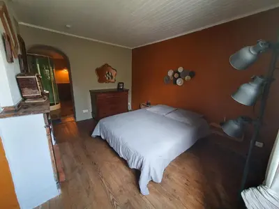 a bedroom with a white bed and a wooden floor at Très belle maison chaleureuse au coeur de Mirepoix in Mirepoix