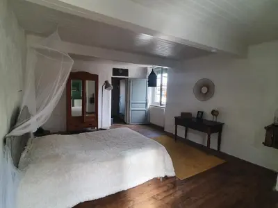a bedroom with a white bed and a table at Très belle maison chaleureuse au coeur de Mirepoix in Mirepoix