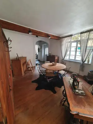 a living room with a table and a wooden floor at Très belle maison chaleureuse au coeur de Mirepoix in Mirepoix