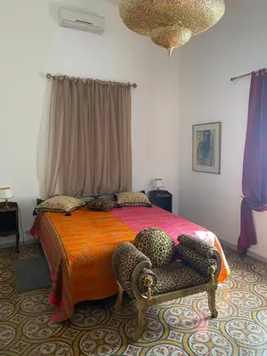 a bedroom with a bed and a chair at Le Relais d'Affiac in Peyriac-Minervois