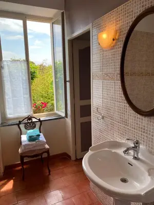 a bathroom with a sink and a mirror and a window at Le Relais d'Affiac in Peyriac-Minervois