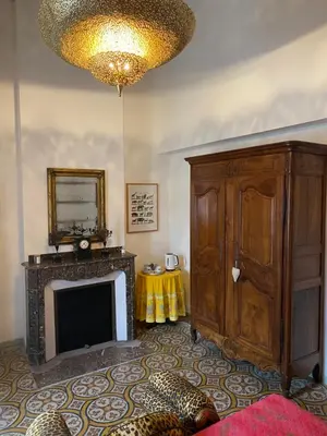 a living room with a fireplace and a television at Le Relais d'Affiac in Peyriac-Minervois