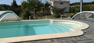 a swimming pool in a backyard with an arbor at La maisonnette du jardin Narbonne in Narbonne