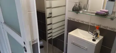 a small bathroom with a sink and a mirror at La maisonnette du jardin Narbonne in Narbonne