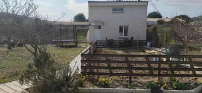 a house with a fence in front of a yard at La maisonnette du jardin Narbonne in Narbonne