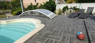 a swimming pool with chairs and a basketball on a patio at La maisonnette du jardin Narbonne in Narbonne