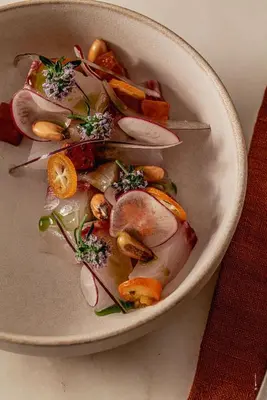 a bowl of food with vegetables on a table at Hôtel Le Mosaïque in Narbonne