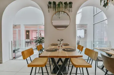 a dining room with a table and chairs and a mirror at Le Meez in Carcassonne