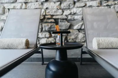 a black table with a bottle of alcohol and two chairs at Le Meez in Carcassonne