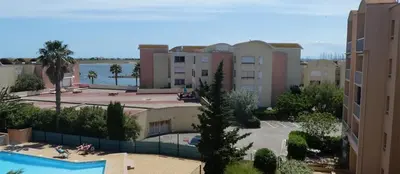 a view of a resort with a pool and buildings at Appartement GRUISSAN Plage du Grazel in Gruissan