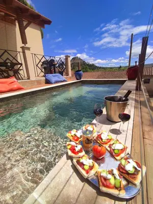 a tray of food on a table next to a swimming pool at VILLA ENTIERE BELLEVUE - Balnéo - Piscine - Clim in Montséret