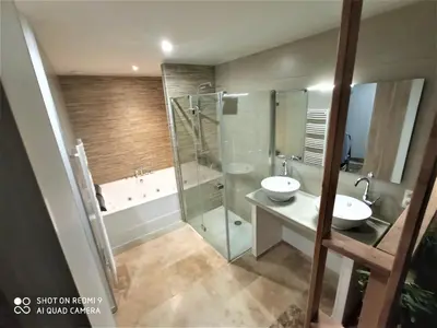 a bathroom with two sinks and a shower and a tub at VILLA ENTIERE BELLEVUE - Balnéo - Piscine - Clim in Montséret
