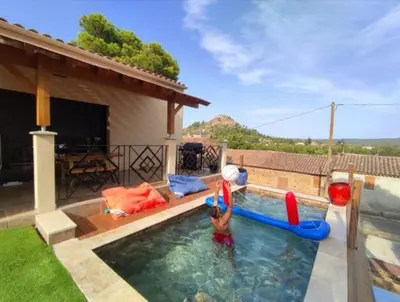 a child playing in a swimming pool with inflatables at VILLA ENTIERE BELLEVUE - Balnéo - Piscine - Clim in Montséret