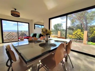 a dining room with a table and chairs and windows at VILLA ENTIERE BELLEVUE - Balnéo - Piscine - Clim in Montséret
