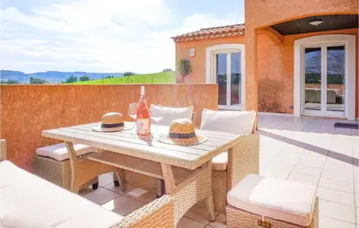 a patio with a table with two bottles of wine at Lovely Home In Cruzy With Kitchen in Cruzy