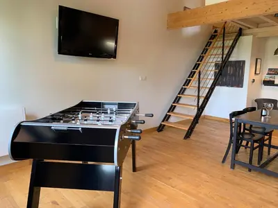a living room with a stove and a tv on the wall at Les gites du Canal du Midi - Gîte La Cordonnerie in Renneville