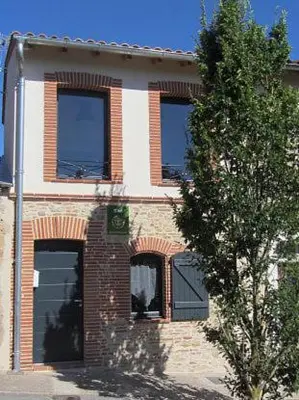 a brick building with windows and a tree in front of it at Les gites du Canal du Midi - Gîte La Cordonnerie in Renneville