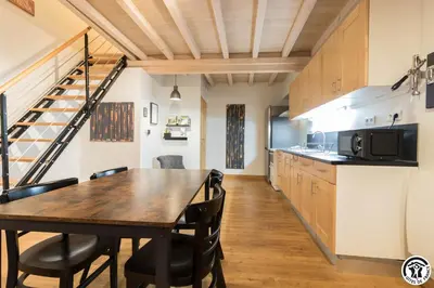 a kitchen and dining room with a table and chairs at Les gites du Canal du Midi - Gîte La Cordonnerie in Renneville