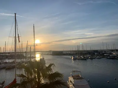 a group of boats docked in a marina at sunset at Appartement vue mer in Gruissan