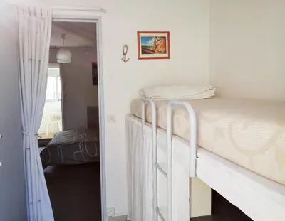 a bedroom with two bunk beds and a doorway at Appartement vue mer in Gruissan
